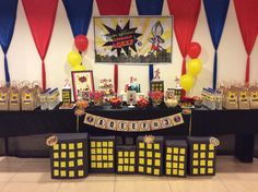 a table with decorations and balloons on it at a birthday party for someone's little hero