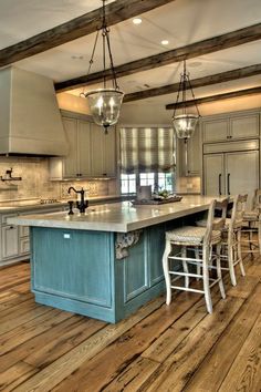 a large kitchen with an island in the center and chairs on the floor next to it