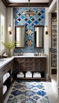 a bathroom with blue and white tiles on the wall, two sinks and mirrors above them