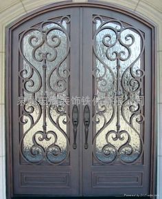 an ornate iron door with glass panels