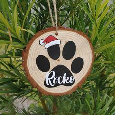 a wooden ornament with a dog's paw and santa hat on it