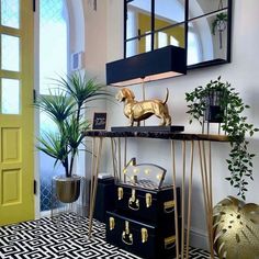 a dog statue on top of a table next to a potted plant and other items