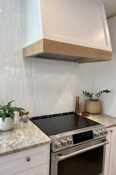 a stove top oven sitting inside of a kitchen next to a wall mounted range hood