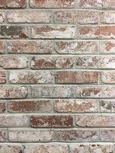 an old brick wall that has been painted brown and white