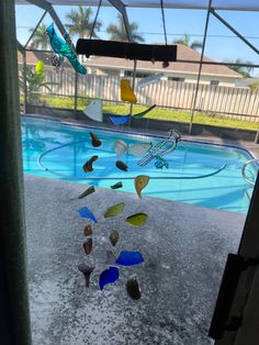 a pool with many different colored glass pieces hanging from it's side and in the air