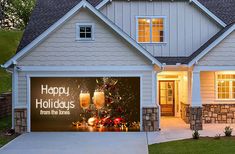 a house with a happy holidays sign on the garage door and lights in the windows