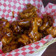 a basket filled with chicken wings covered in sauce