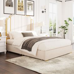 a bedroom with white walls and wood floors, including a large bed in the center