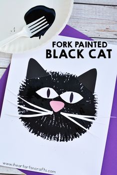 a paper plate with a black cat face on it and fork next to the image