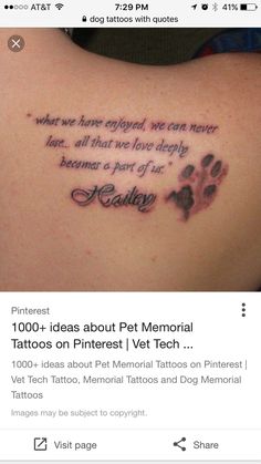 the back of a woman's shoulder with an image of a dog paw tattoo on it