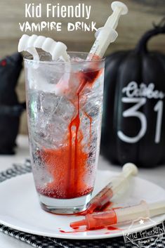 a glass filled with liquid and toothbrushes on top of a white plate