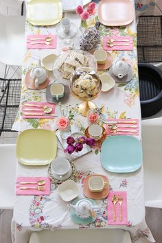 a table set with plates, cups and saucers for tea party guests to enjoy