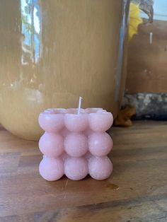 a pink candle sitting on top of a wooden table