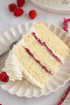 a slice of white cake with raspberry filling on a plate next to a fork