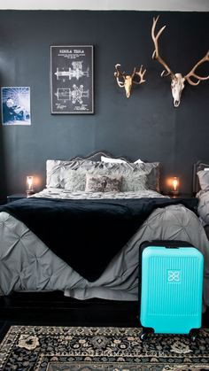 a bed room with a neatly made bed and a blue suitcase