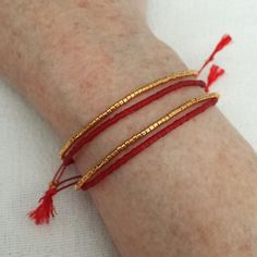 Red Adjustable Friendship Bracelets With Tiny Beads, Adjustable Red Friendship Bracelets With Tiny Beads, Red Bohemian Bracelets With Gold Beads, Minimalist Gold Bracelet For Festivals, Red Friendship Bracelets With Sliding Knot, Red Beaded Friendship Bracelets, Red Bracelets With Tiny Beads As Gift, Red Friendship Bracelets With Gold Beads As Gift, Red Friendship Bracelet With Gold Beads As Gift