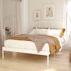 a white bed sitting on top of a hard wood floor