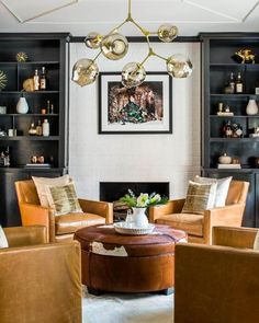 a living room filled with furniture and a fire place in front of a wall mounted bookcase