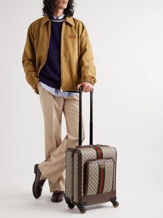 Gucci's 'Savoy' carry-on suitcase is made from the brand's 'GG Supreme' canvas, which is based on an archival design from the 1930s. Trimmed with leather, it's fitted with two spacious compartments and has a retractable telescope handle. Traveling through the airport is made easy thanks to the 360° wheels, and it has an identification tag and a lock and key to keep your things secure. Designer Luggage With Sleeve For Travel, Designer Luggage With Sleeve For Trip, Luxury Travel Cases, Designer Travel Cases With Luggage Sleeve, Luxury Cases With Luggage Sleeve For Trips, Luxury Luggage With Leather Trim For Business Trips, Luxury Travel Cases With Luggage Sleeve, Designer Luggage For Trips, Luxury Luggage With Sleeve For Business Trips