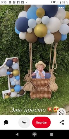 a baby in a basket with balloons and the number one on it's side