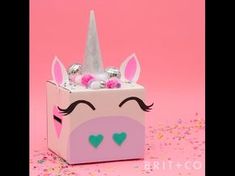 a pink box with a unicorn's face painted on it and confetti