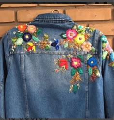 a denim jacket with colorful flowers on it