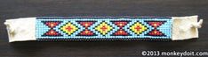 a beaded bracelet on a table with a white band and blue, red, yellow, and green beads