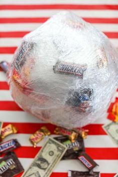 a bag filled with candy sitting on top of a red and white striped table cloth