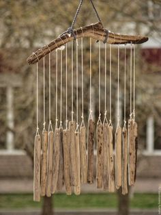 a wind chime made out of driftwood hanging from a tree