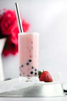 a strawberry milkshake with strawberries on the side