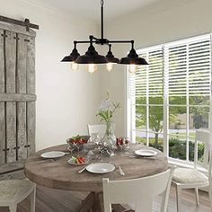 a dining room table with white chairs and wooden shutters in front of the window