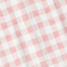 a pink and white checkered tablecloth is seen in close up view with no image on it