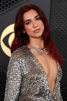 a woman with red hair wearing a silver dress