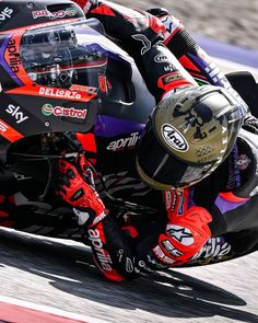 a person riding on the back of a motorcycle down a race track in a helmet