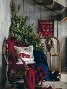 a christmas tree sitting on top of a wooden chair next to a red and white blanket