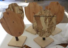 three pieces of wood sitting on top of a white table next to other wooden objects