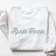 Après Tennis Sweatshirt I love to help my customers with custom orders, if you have a specific request (printing on the sleeve, design on a shirt, or a swap to a Comfort Colors sweatshirt), please message me and I will promptly get back to you! Please review the size chart in the images before you place your order. If you have any questions about sizing, I would be happy to help! If you don't see the specific color that you are looking for, please message me and I will get back to you quickly. PRODUCTION and SHIPPING Production takes about 1-3 days and standard shipping is 3-5 business days. If you are in a rush, please message me and I can help with shipping upgrades. RETURNS & EXCHANGES My goal is to ensure that my customers are completely satisfied with their purchase. If your product a White Team Spirit Sweatshirt With Name Print, Sporty Crew Neck Sweatshirt With Custom Text, Sporty Cotton Sweatshirt With Custom Text, White Sweatshirt With Name Print And Relaxed Fit, White Sweatshirt With Name Print, Relaxed Fit, Relaxed Fit White Sweatshirt With Name Print, Custom Print Cotton Sweatshirt For Sports Events, Custom Text White Long Sleeve T-shirt, White Long Sleeve T-shirt With Custom Text