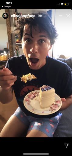 a man holding a plate with a piece of cake on it in front of his face