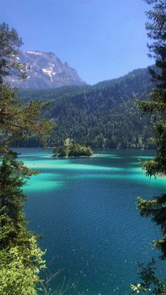 the blue water is surrounded by trees and mountains