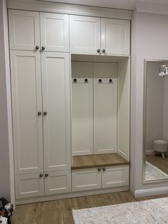 a large white closet with wooden flooring and built - in storage units on either side