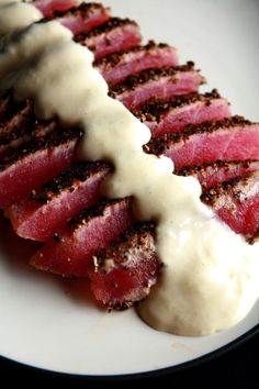 a white plate topped with meat covered in sauce