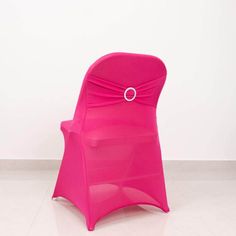 a bright pink chair with a ring on it's belt sits in front of a white wall