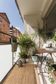 an apartment balcony with potted plants on the floor