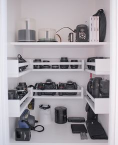 there are many cameras on the shelves in this room, and one is open to show it's contents