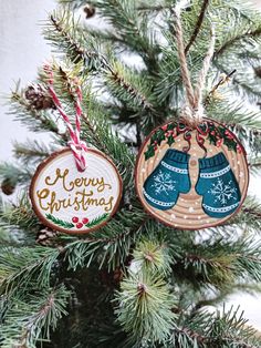 two wooden ornaments hanging from a christmas tree