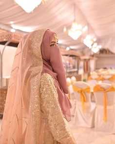 a woman in a pink hijab and gold dress