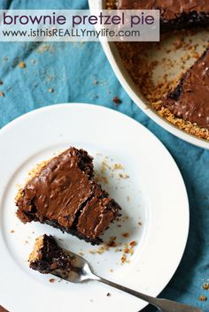 a piece of chocolate cake on a plate with a fork next to it and another slice missing