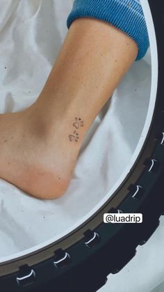 a person's foot with a small tattoo on the side of their left leg