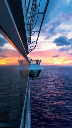 the sun is setting over the ocean as people are on a boat