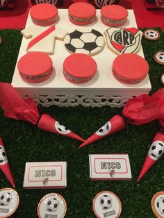 a table topped with cupcakes covered in frosting and soccer themed icing